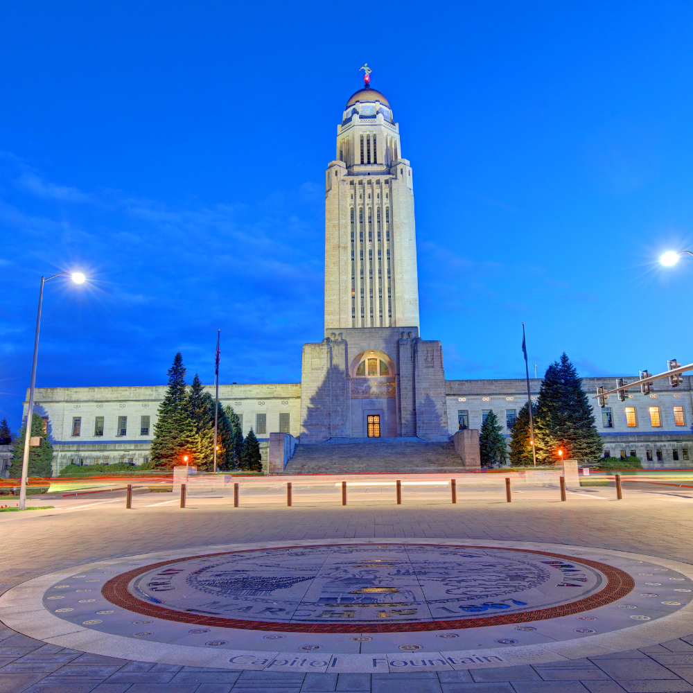 Nebraska State Capitol building at night with a circular design in the foreground.